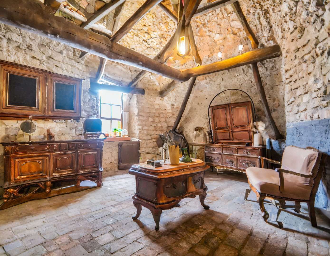 Débarras de mobilier ancien dans la cave voutée d'une maison en pierre dans le département de l'Oise